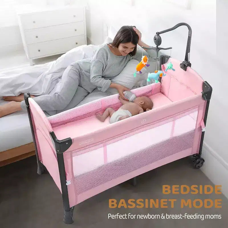 JOYMOR Baby Bedside Bassinet, Baby Bassinet, Pack n Play Convert Playpen, Quick Foldable Travel Bed, Wheels & Brake, Carry Bag for Boys Girls (Pink)